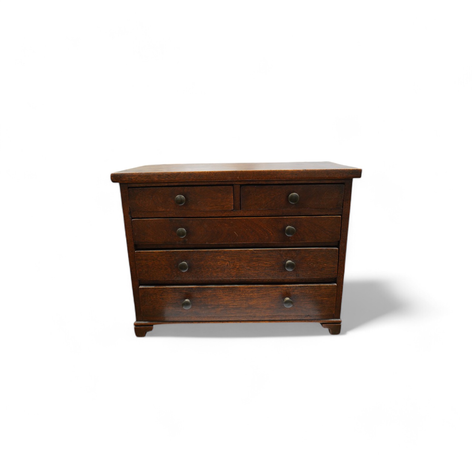 A miniature mahogany three long, two short, chest of drawers 32cms wide. Condition - good